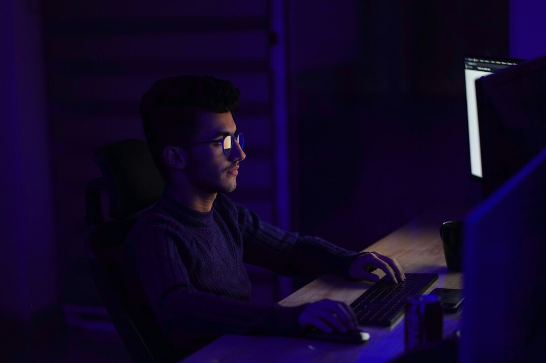 Software developer writing code on a laptop screen